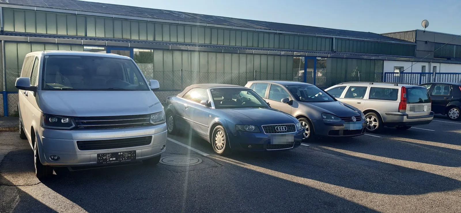 Fahrzeuge auf dem Hof vor der Werkstatt